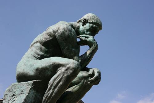 Sculpture by Rodin of man thinking, arm resting on knee and chin resting on hand